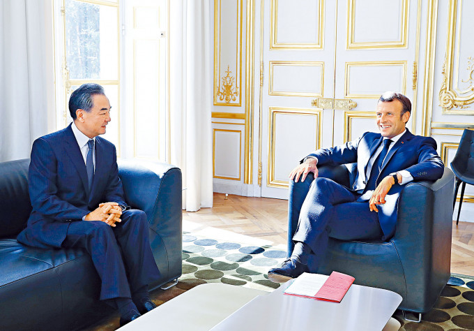 法國總統馬克龍（右）在巴黎愛麗舍宮會見到訪的王毅。